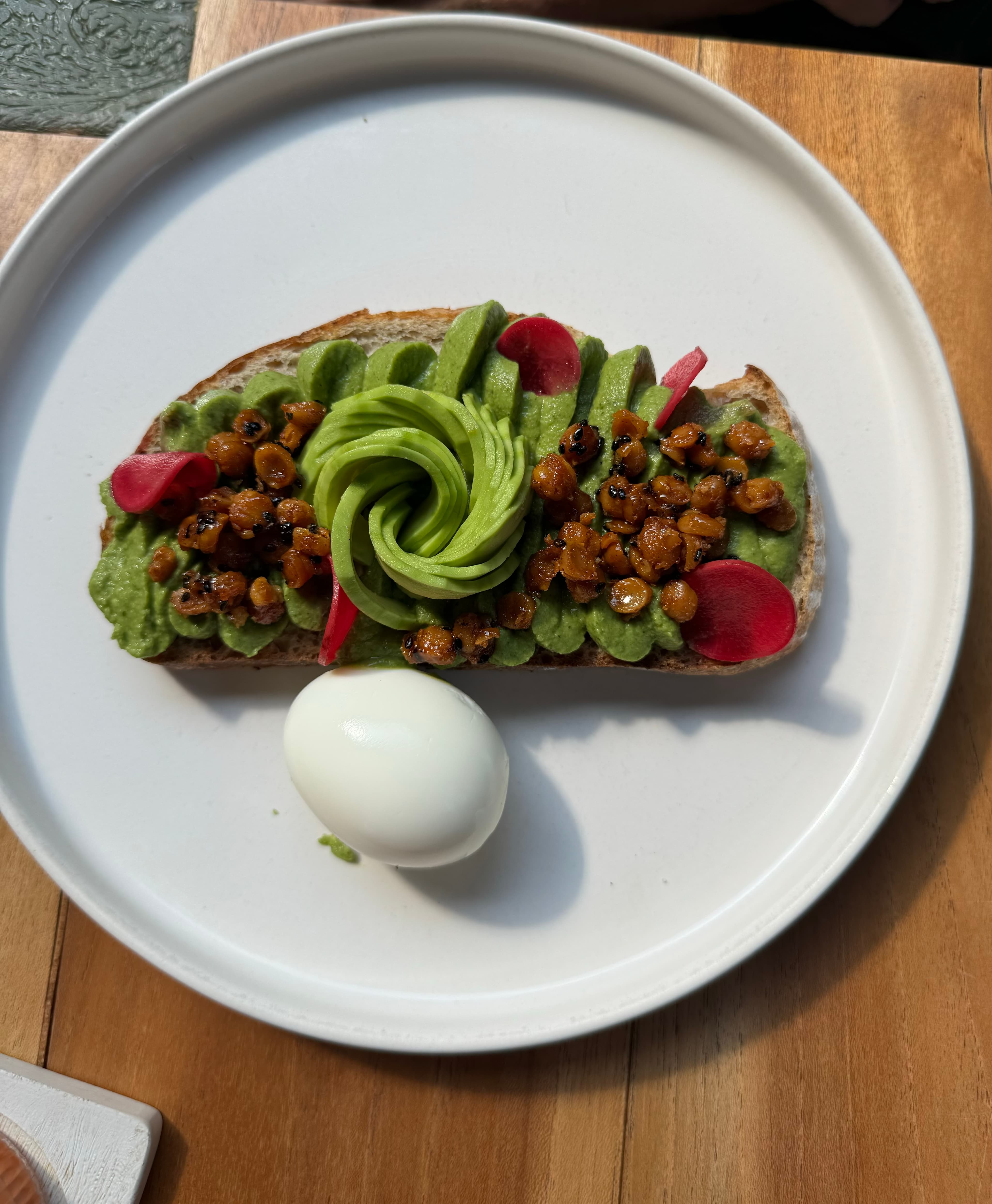 Avocado toast with pickled radish, chickpeas, and a soft-boiled egg