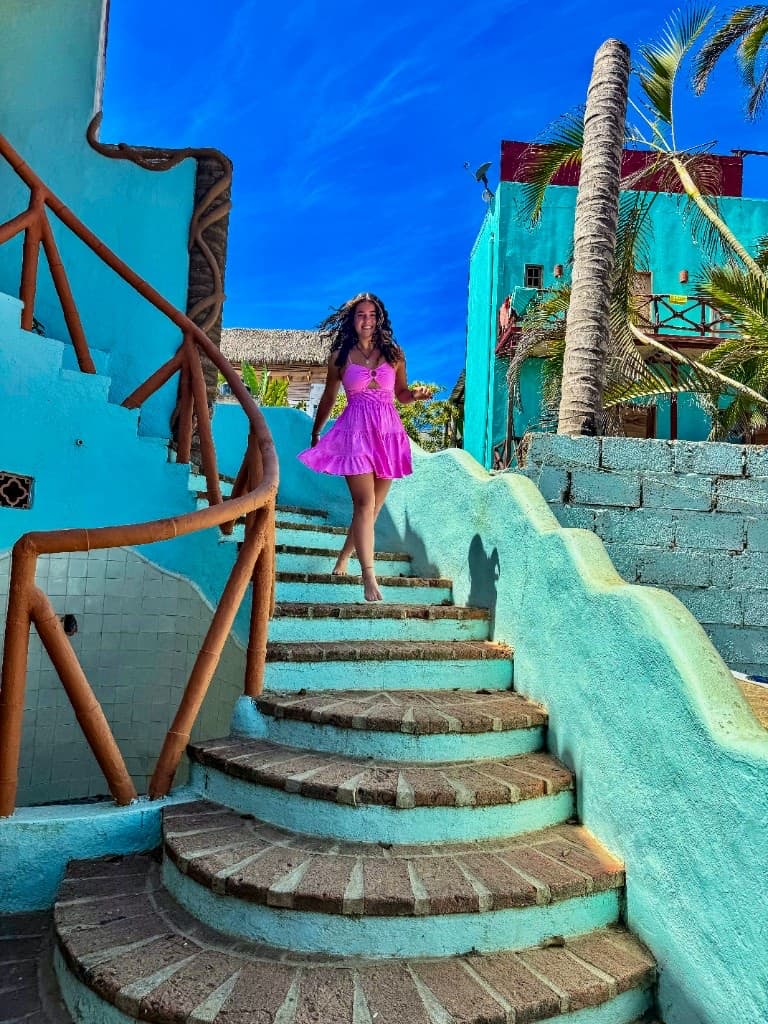 Jaz on turquoise stairs in a bright tropical setting